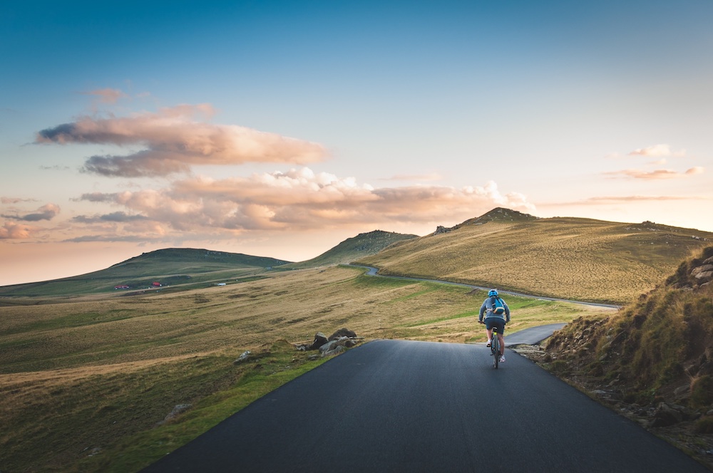Foto de um ciclista em meio a montanhas